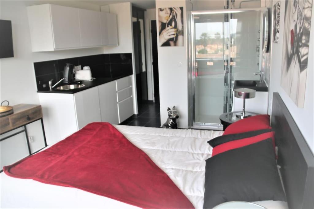 une chambre avec un lit avec une couverture rouge dessus dans l'établissement Studio 315, Port Vénus au village naturiste, au Cap d'Agde