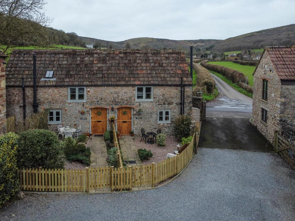 an old stone house with a wooden fence at Wavering in Axbridge