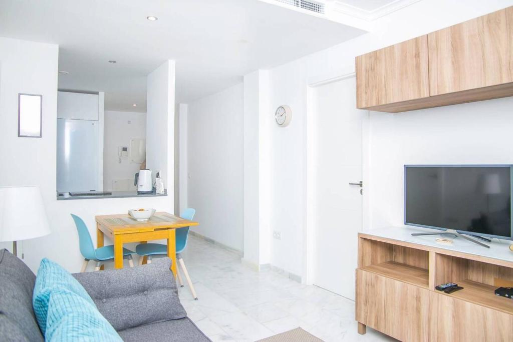 salon z kanapą, stołem i telewizorem w obiekcie Cozy apartment perfect for couples SmartTv+WiFi w mieście Fuengirola
