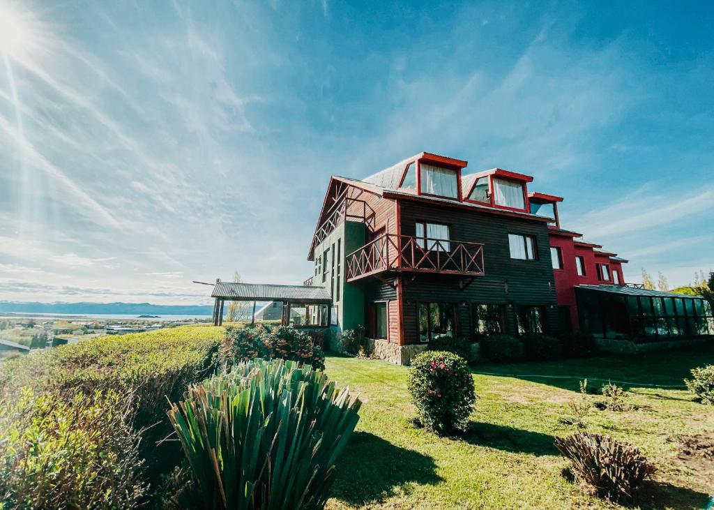 uma casa no topo de uma colina com o sol brilhando em Lupama em El Calafate