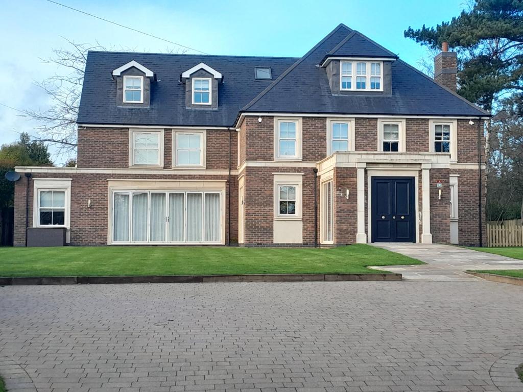a large brick house with a driveway at Luxurious New Build in Nottingham