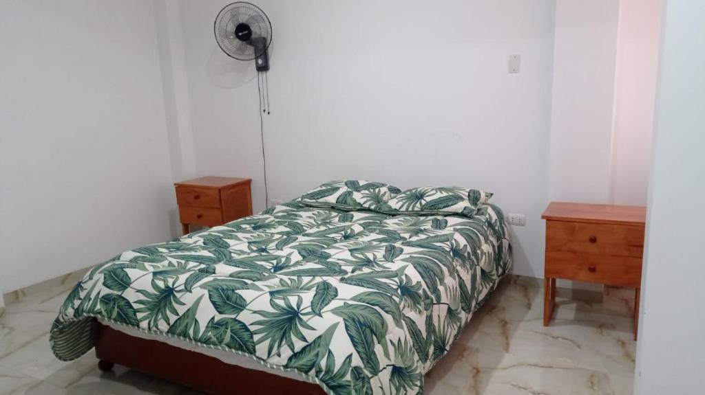 a bedroom with a bed with a green and white comforter at Doña Amalia in Lima