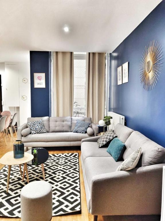 - un salon avec deux canapés et un mur bleu dans l'établissement Quiet apartment near Saint-Lazarre - 10P, à Paris