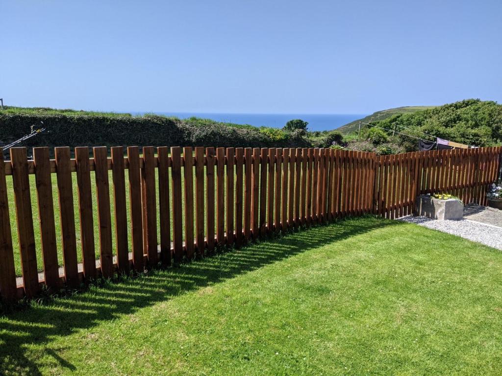 a wooden fence in a yard with green grass at 1 Bed in Bude 43697 in Morwenstow