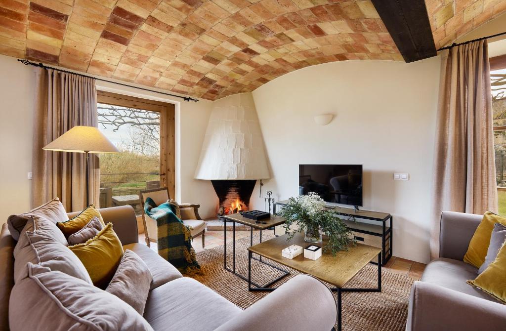 a living room with a couch and a fireplace at Turismo Rural Mas Ametller in Fontclara