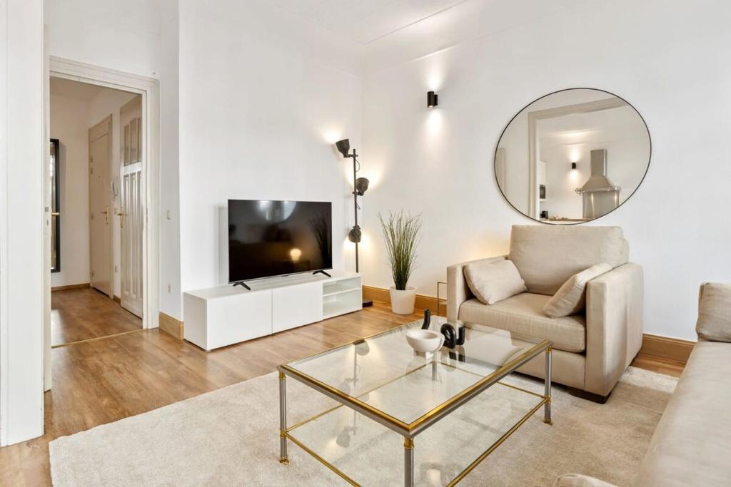 ein Wohnzimmer mit einem Sofa und einem Tisch in der Unterkunft Luminous Luxe - White and Gold in Luxemburg (Stadt)