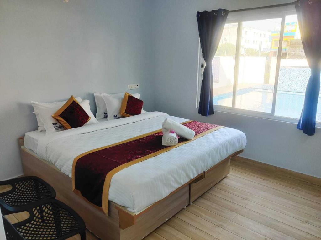 a bedroom with a large bed with a window at Super OYO Flagship Chez Pondy Near Serenity Beach in Kottakupam