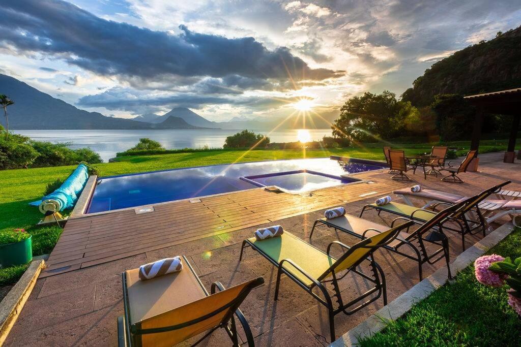 a deck with chairs and a pool with a view of the water at Casa Panimul, Atitlán Lake in Sololá