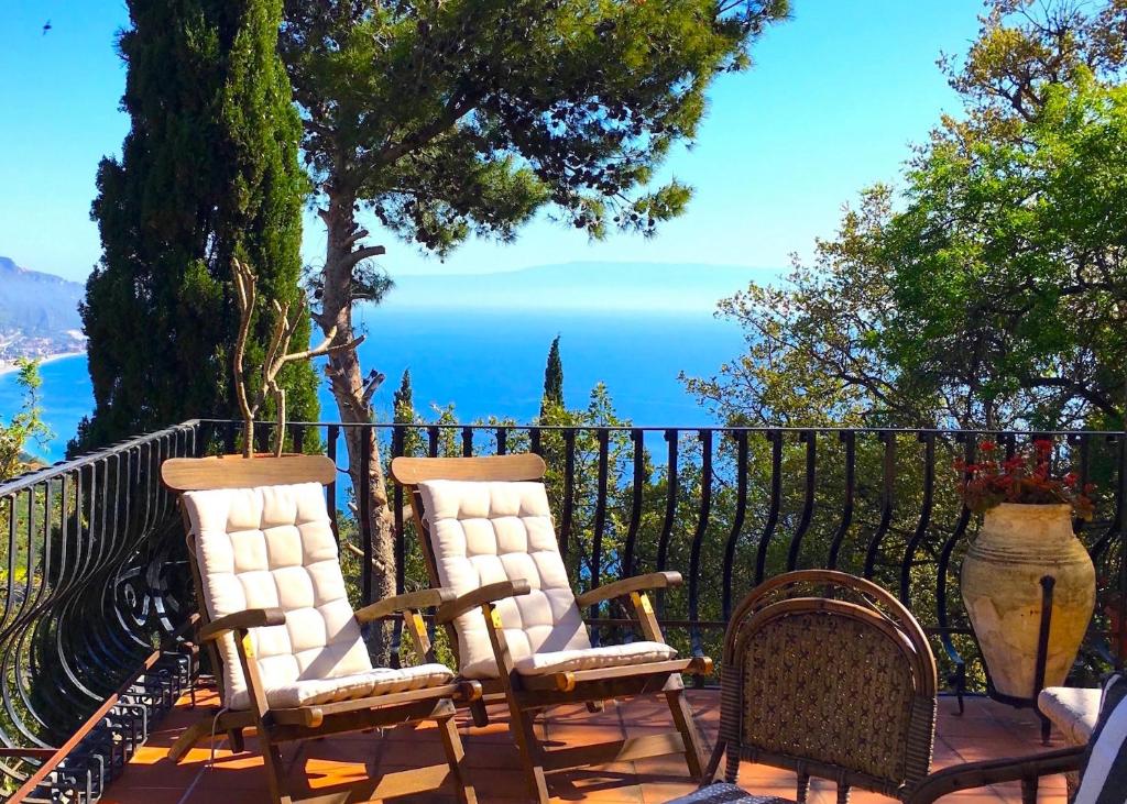 twee stoelen op een terras met uitzicht op de oceaan bij CASA LUDOVICA TAORMINA with Sea View Terrace in Taormina