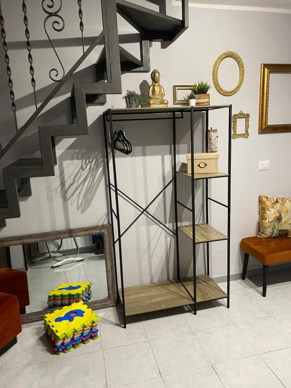 un salon avec un escalier et une étagère dans l'établissement Nel cuore di Pescasseroli, à Pescasseroli