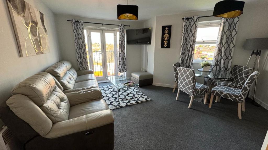 a living room with a couch and a table and chairs at Spacious 1 Bedroom Apartment In Wigan in Shevington