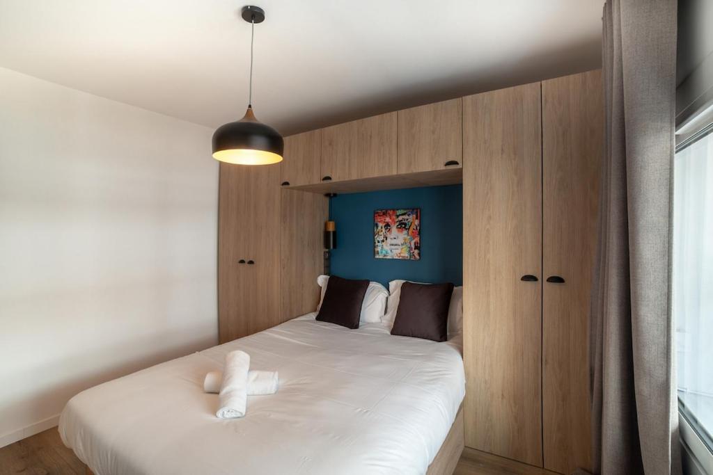 アンティーブにあるCharmant Appartement Antibesのベッドルーム1室(白い大型ベッド1台、木製キャビネット付)