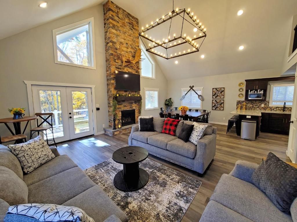 Una sala de estar con dos sofás y una chimenea. en Timber Top Terrace - Huge Luxury 6 BR - Sleeps 16 Linens and Towels Included, en Albrightsville