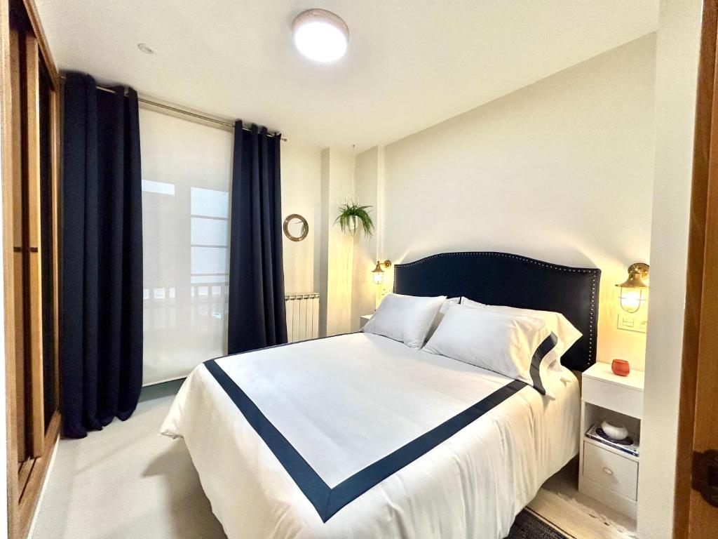 Un dormitorio con una cama grande y una ventana en CAMBARAL AS DE GUIA, en Luarca