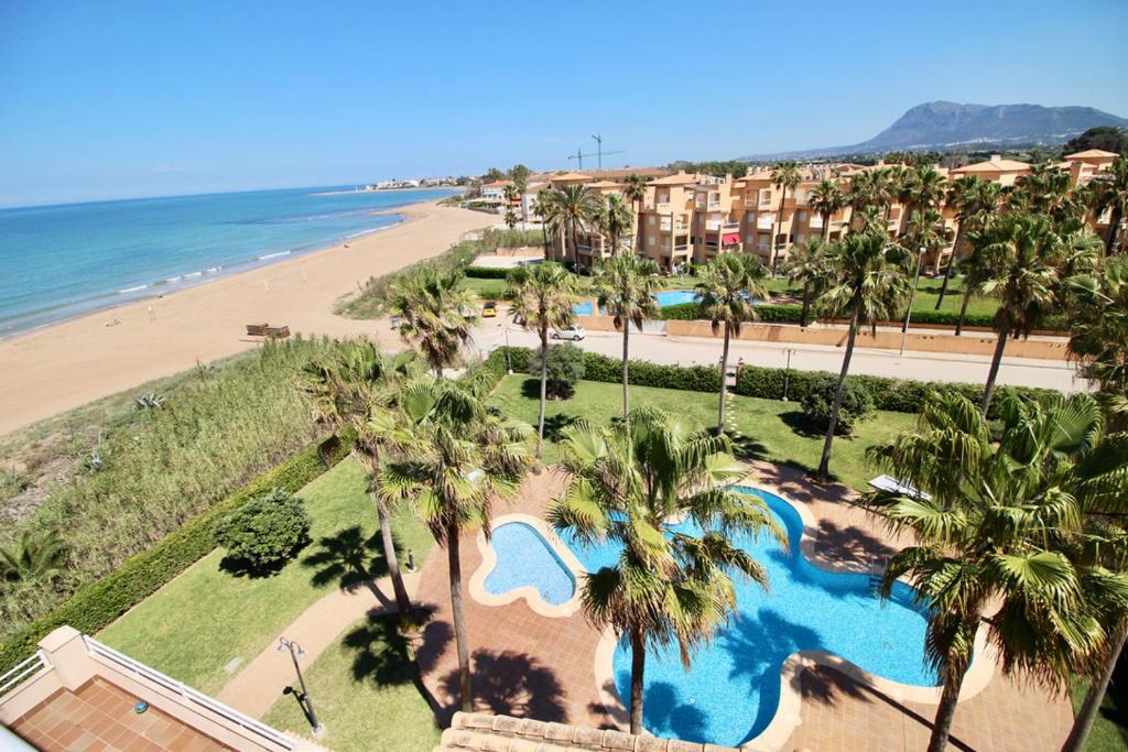 uma vista aérea de um resort com palmeiras e uma praia em El Amanecer 93 em Denia