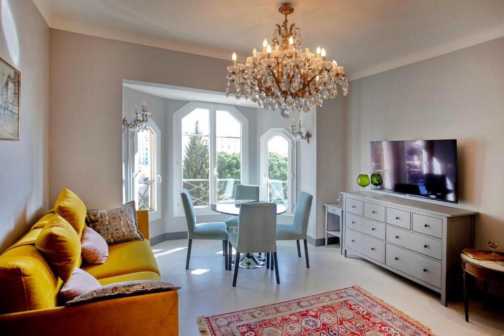 un salon avec un canapé jaune et une salle à manger dans l'établissement Appartement 5 min des plages Croisette, à Cannes