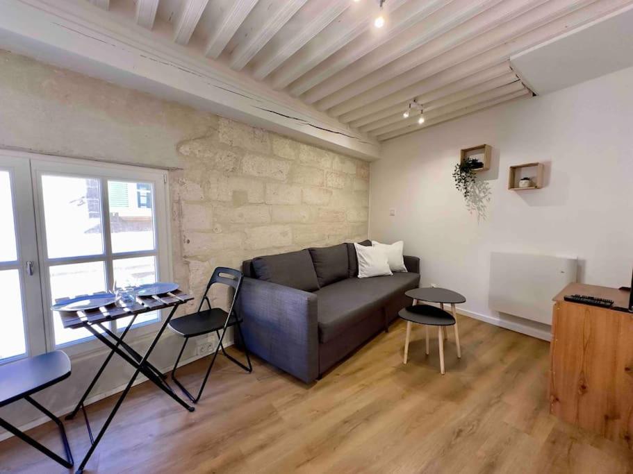 ein Wohnzimmer mit einem Sofa und einem Tisch in der Unterkunft Studio Hyper Centre in Avignon