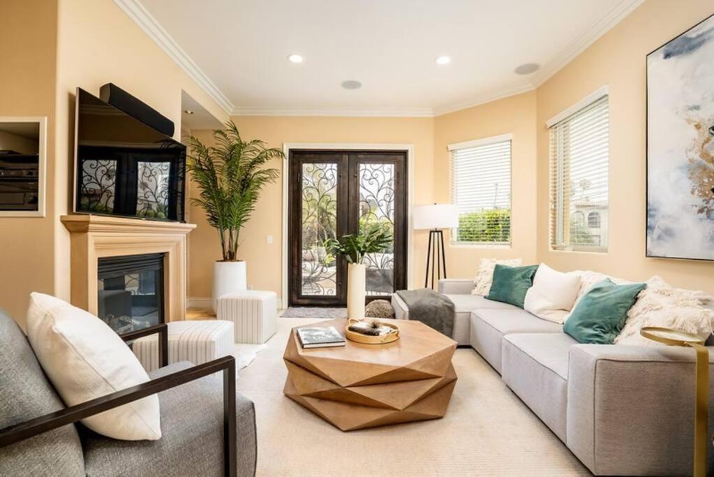 a living room with a couch and a fireplace at Luxury Beach House Rooftop Deck in Huntington Beach