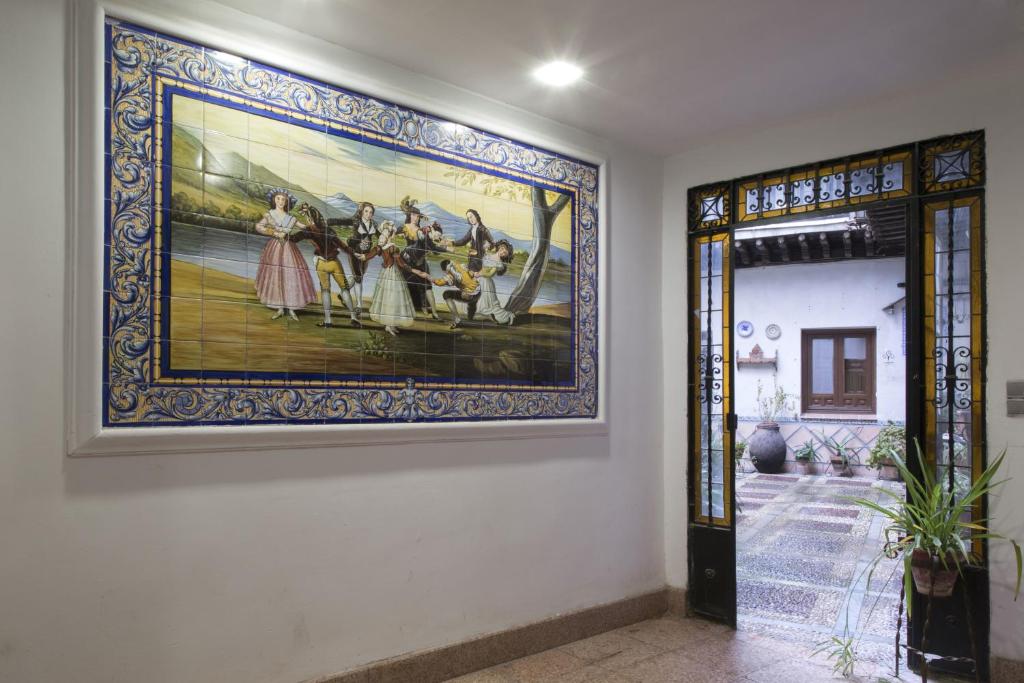 une grande peinture sur un mur à côté d'une porte dans l'établissement El Patio de Mi Casa, à Tolède