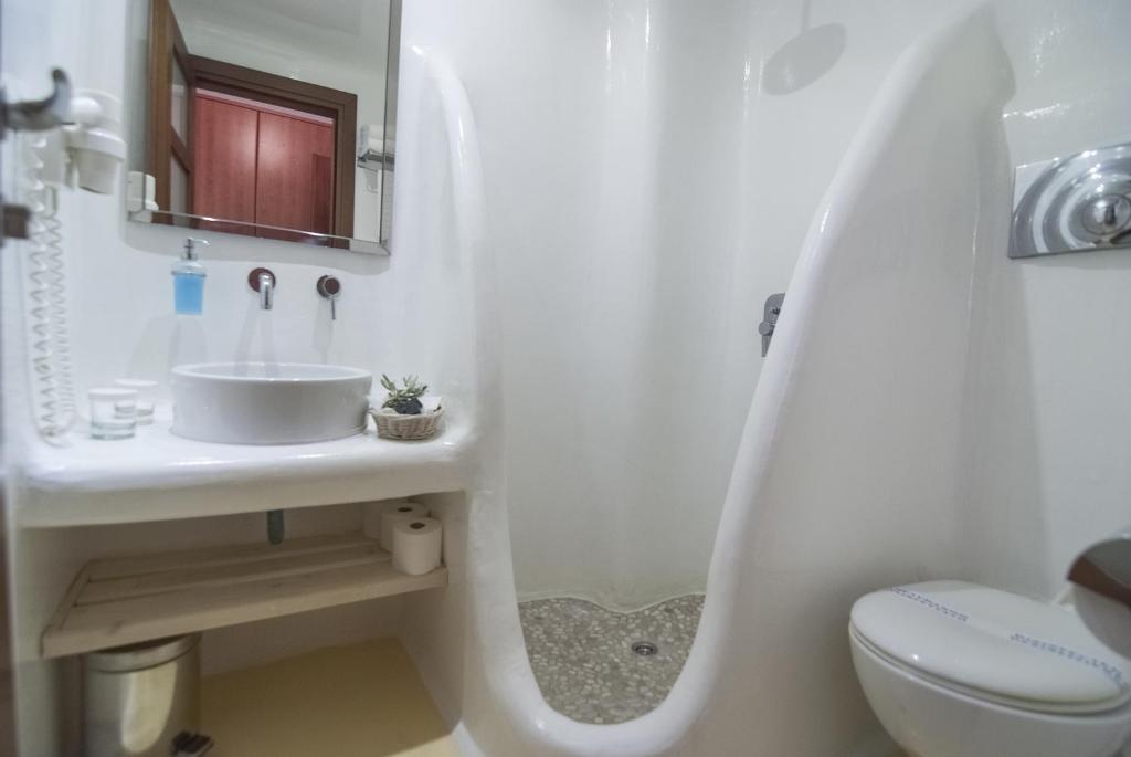 a white bathroom with a sink and a toilet at Zephyros in Paraga