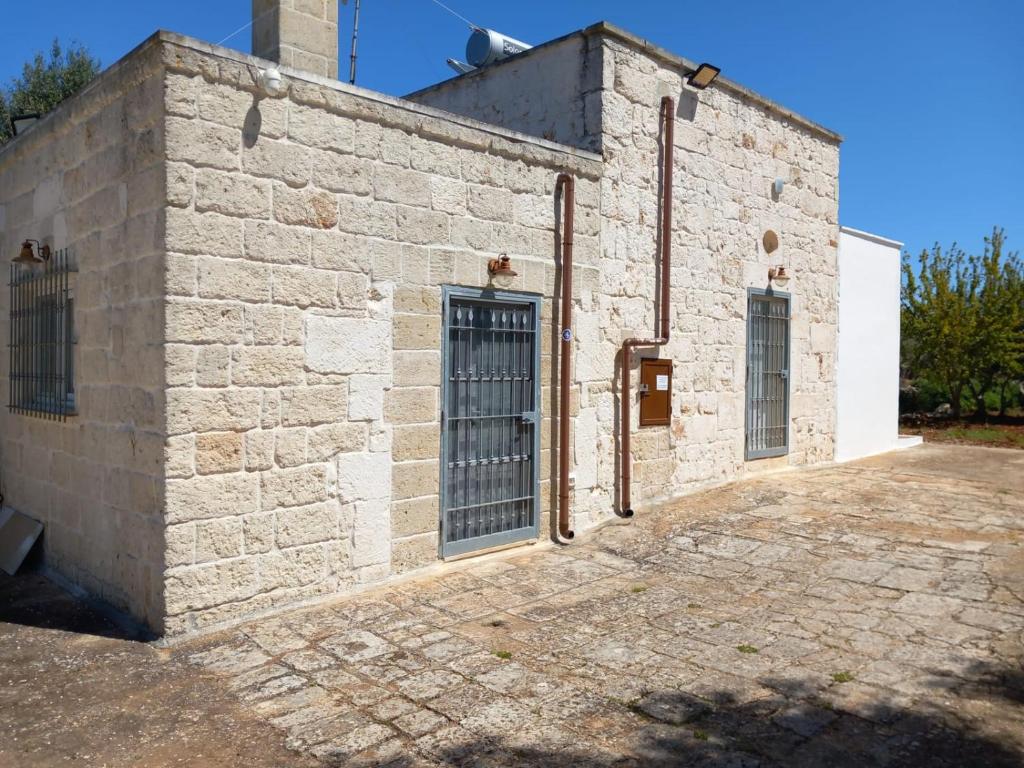 an old brick building with gates on the side at casina tra gli ulivi in Ostuni