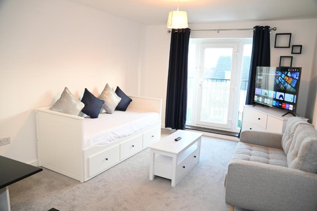 Dormitorio blanco con cama blanca y sofá en Windsor to Heathrow spacious 2 Bedroom 2 Bath Apartment with Parking - Langley village Elizabeth Line to London, Reading, Oxford en Slough