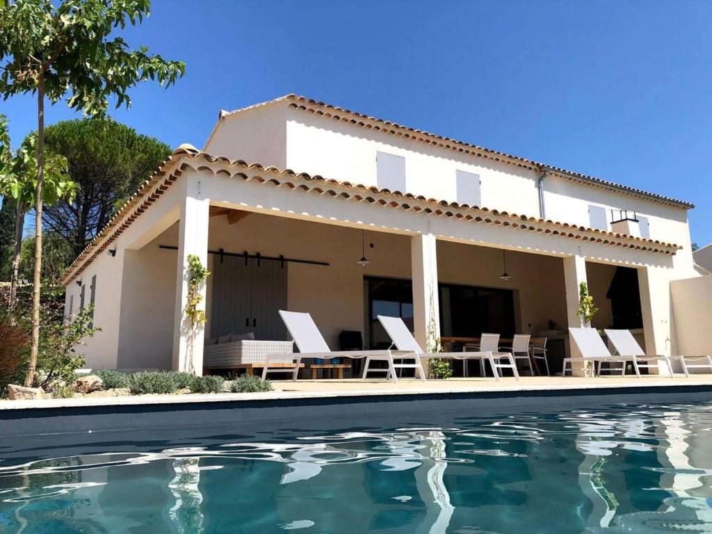 a villa with a swimming pool in front of a house at Villa de 4 chambres avec piscine privee terrasse et wifi a Malaucene in Malaucène