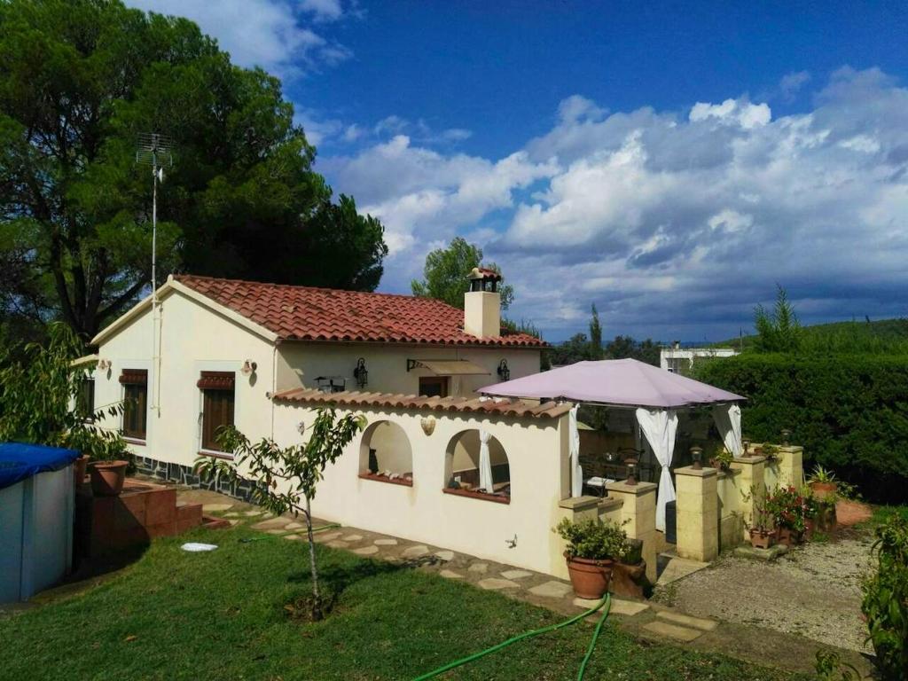 a small white house with a roof at Cosy Chalet in L'Arboçar with Private Pool, 65 sqm in Barcelona