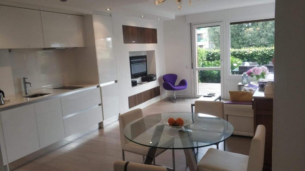 a kitchen and living room with a glass table at Apartamento con jardín in Barro de Llanes