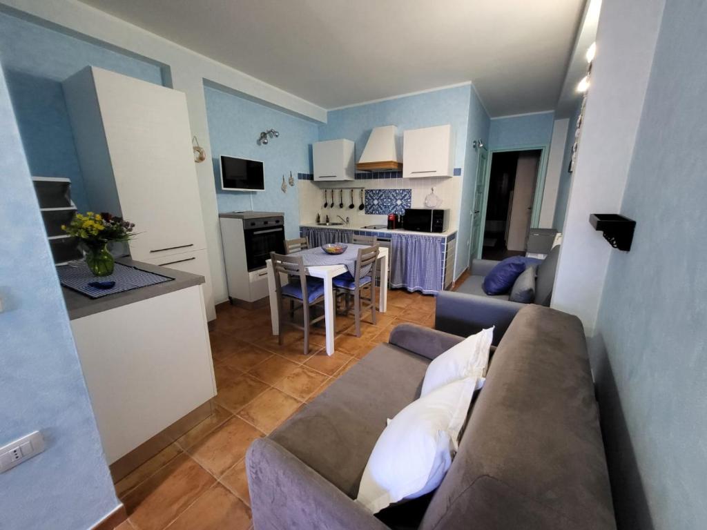 a small living room with a couch and a kitchen at La brezza marina in SantʼAntìoco