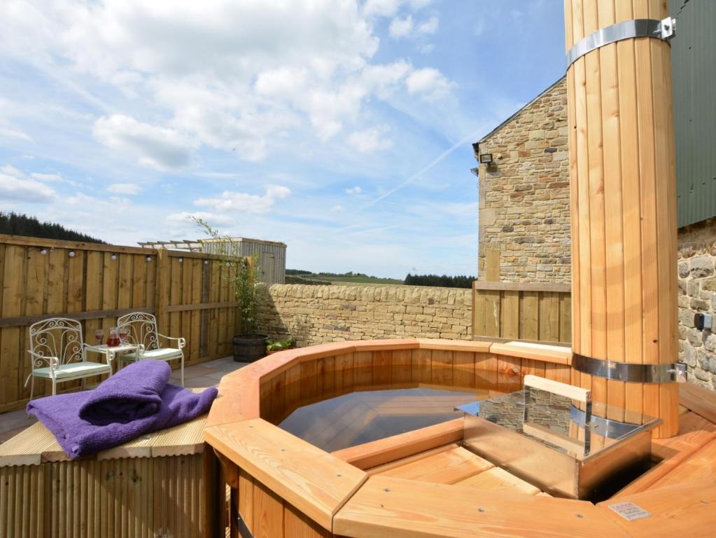 a hot tub on a wooden deck with a building at 1 Bed in Durham HISHO in Lanchester