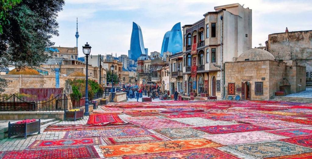 a street with colorful carpets in the middle of a city at Sweet Home Hostel in Baku