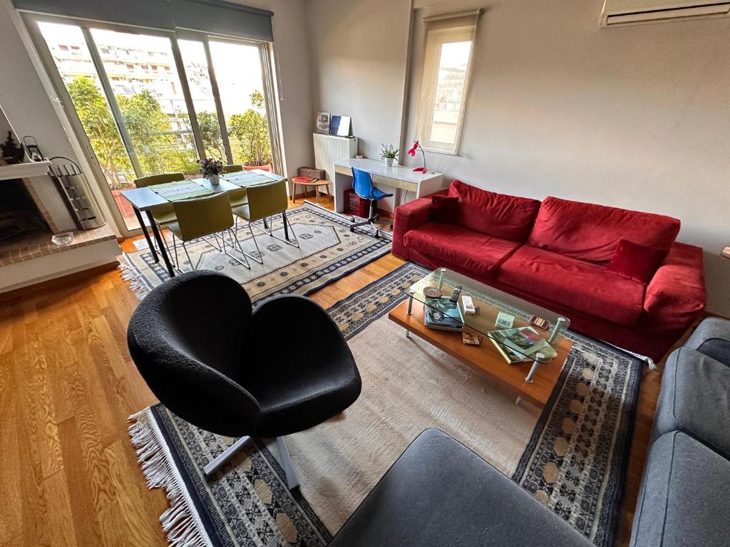 a living room with a red couch and a table at Ano Patisia Luxury Apartment in Athens