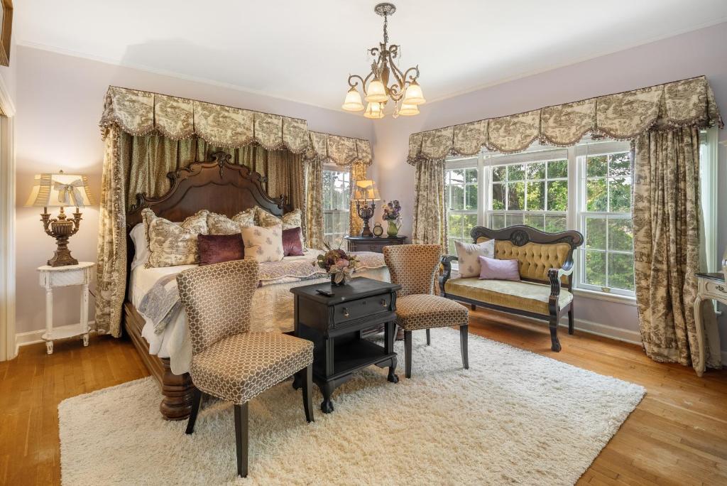 フォートスミスにあるGrand Mansion-Blooming Garden suite!のベッドルーム1室(ベッド1台、テーブル、椅子付)