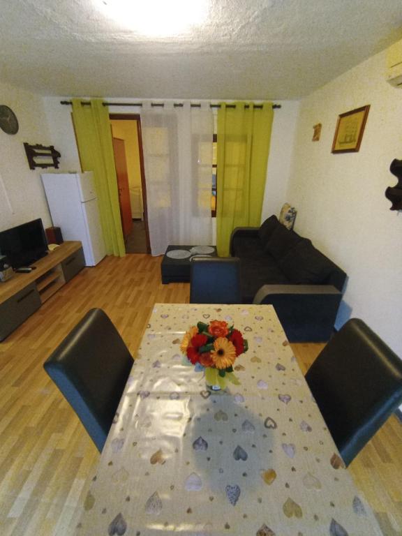 ein Wohnzimmer mit einem Tisch mit Blumen darauf in der Unterkunft Apartments Villa Marta - Begovic in Kotor
