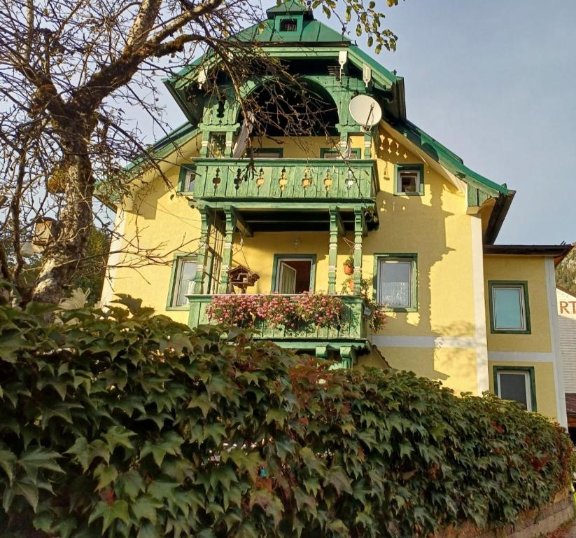 a yellow building with a balcony with flowers on it at Appartement Franz in Bad Ischl