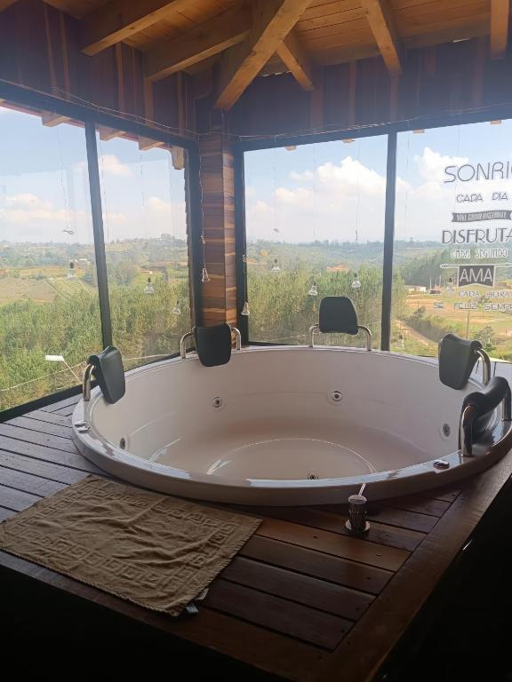 uma grande banheira num quarto com janelas em Cabaña con Jacuzzi ilimitado/BBQ/Hermosas vistas em San Vicente