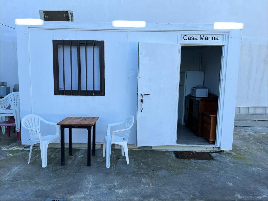 een kamer met een tafel en stoelen naast een deur bij Casa Marina in Ceuta