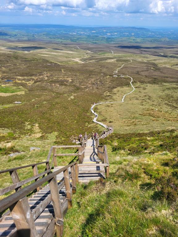 un grupo de personas caminando por un sendero de madera en una colina en Claragh Cottage, en Cavan