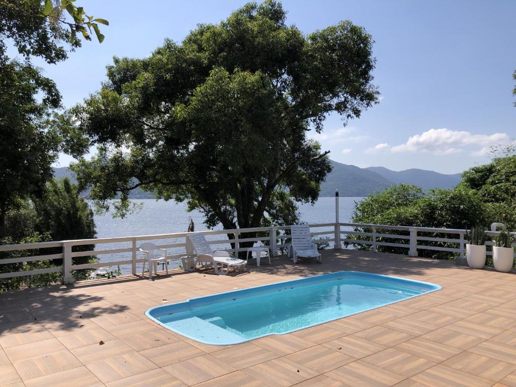 a swimming pool on a deck with a view of the water at Casa com Piscina e Acesso a Lagoa da Conceição NG0811 in Florianópolis