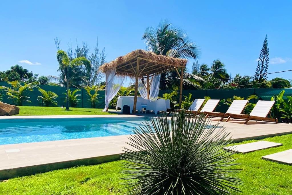 a swimming pool with chairs and a gazebo at Villa du Levant-6/8 pers-Piscine in Saint-François