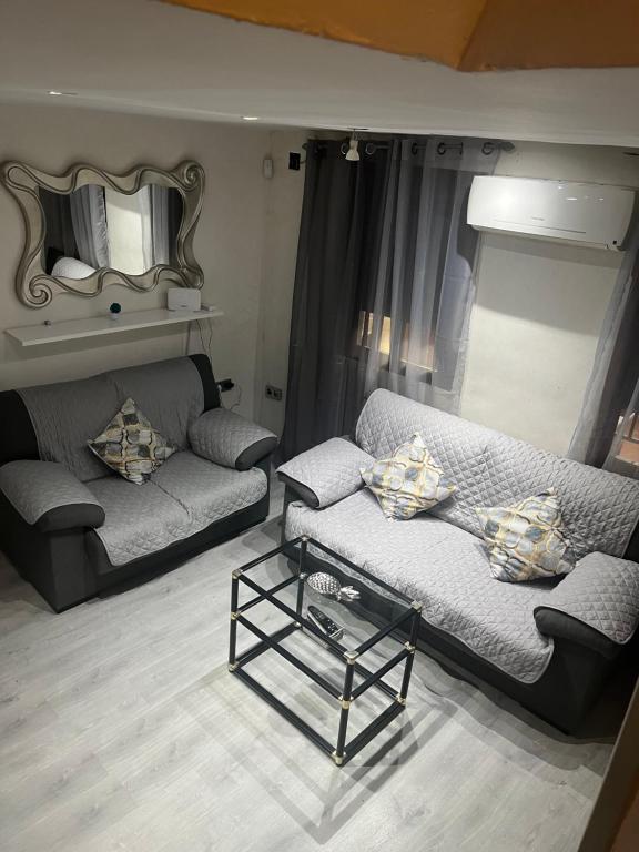 a living room with two couches and a mirror at Preciosa casa soleada en mirador albaicin in Granada