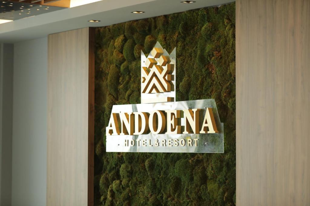 un letrero de hotel y resort anomonial en una pared en Andoena Resort, en Lipljan
