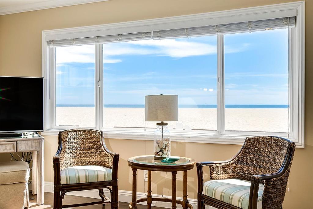 uma sala de estar com duas cadeiras, uma mesa e uma janela em Beachfront Getaway on the Sand em Newport Beach