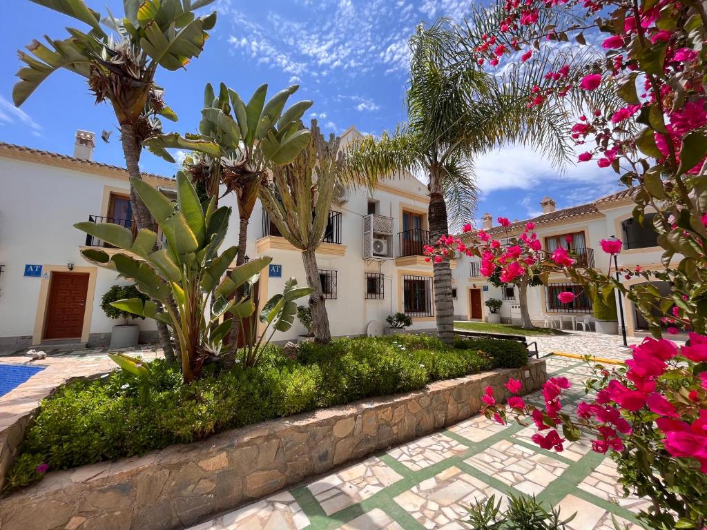 ein Haus mit Palmen und Blumen davor in der Unterkunft Apartamento Concha del Mar en Vera Coast in Playas de Vera