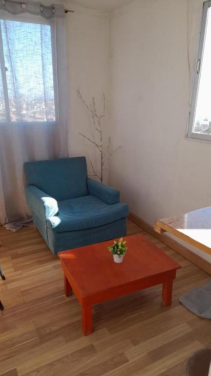 a living room with a blue couch and a coffee table at Hospedaje entre rokas in Huasco