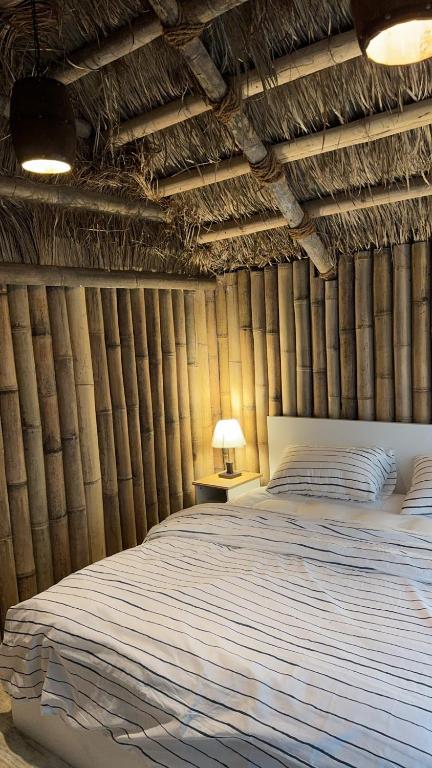 a bedroom with a bed in a bamboo wall at اكواخ البامبو in Malham