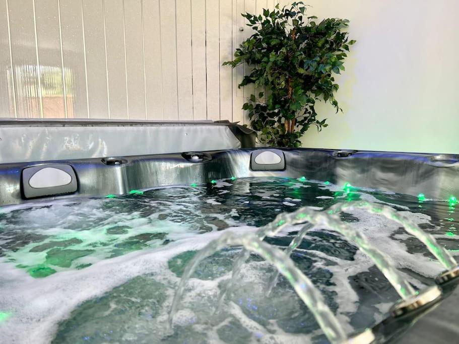 a hot tub filled with water with a plant at Hambleton Hideaway in Stokesley