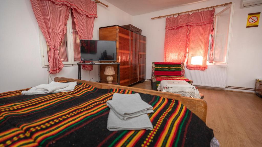 a bedroom with a bed with a colorful blanket at Etno Apartmani ''Vlaška kuća'' in Kladovo