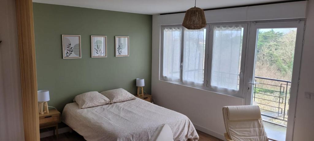 a bedroom with a bed and a window at Studio neuf avec balcon et parking privé in Rochefort